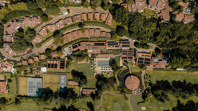 Aerial view of Hotel Avándaro showcasing its modern architectural design and green pathways within the forested landscape.
