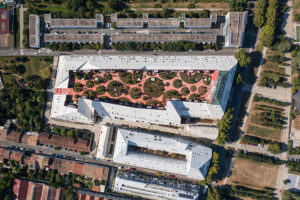 "Aerial view of the Ilot Queyries project in Bordeaux, France, showcasing its unique design with a central green courtyard and multi-story buildings."