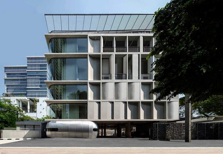 Modern building facade in Bangkok featuring curved concrete panels and glass