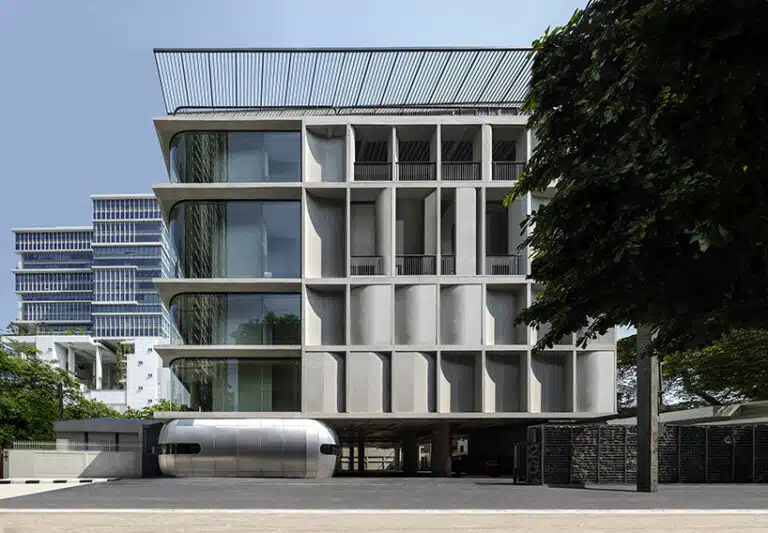 Modern building facade in Bangkok featuring curved concrete panels and glass