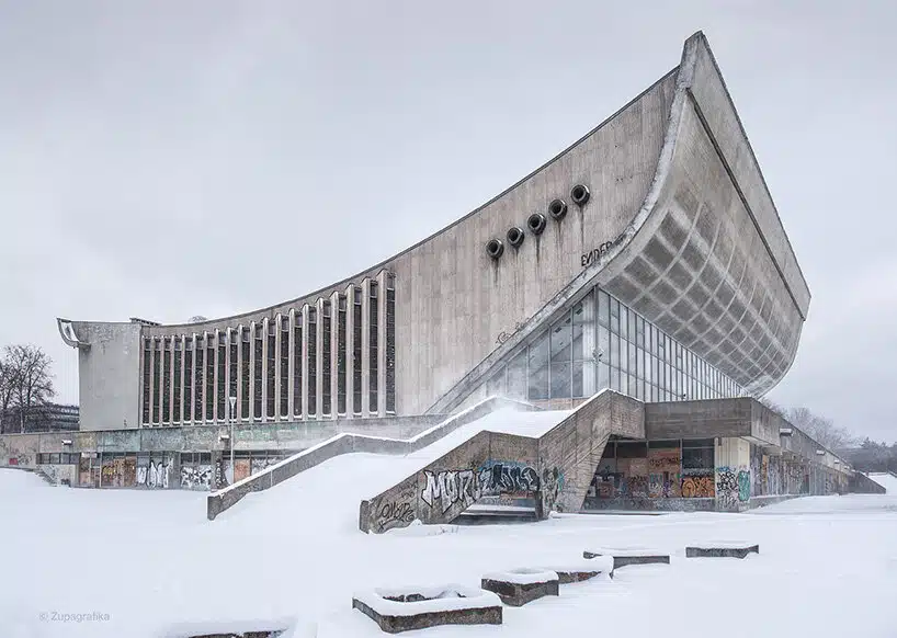 An abandoned snow-covered building with graffiti, representing decay in former Eastern Bloc suburbs.