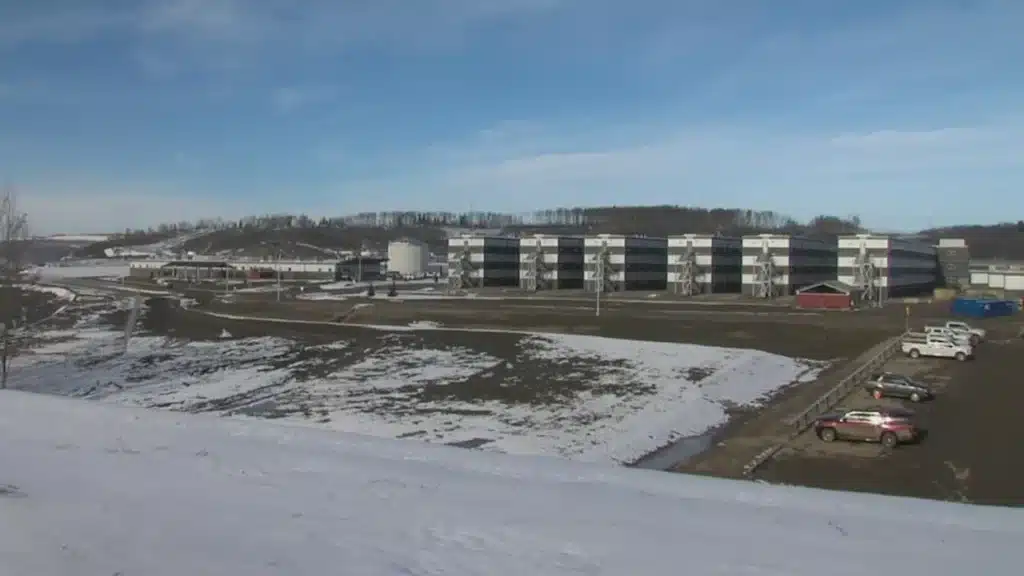A modern industrial building surrounded by snow-covered natural land.