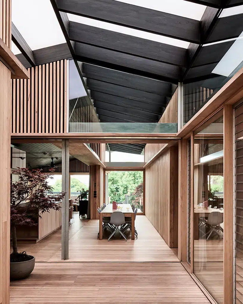 تصميم داخلي مميز لمنزل كروس مع استخدام الأخشاب الطبيعية والنوافذ المنزلقة التي تربط بين الداخل والخارج.