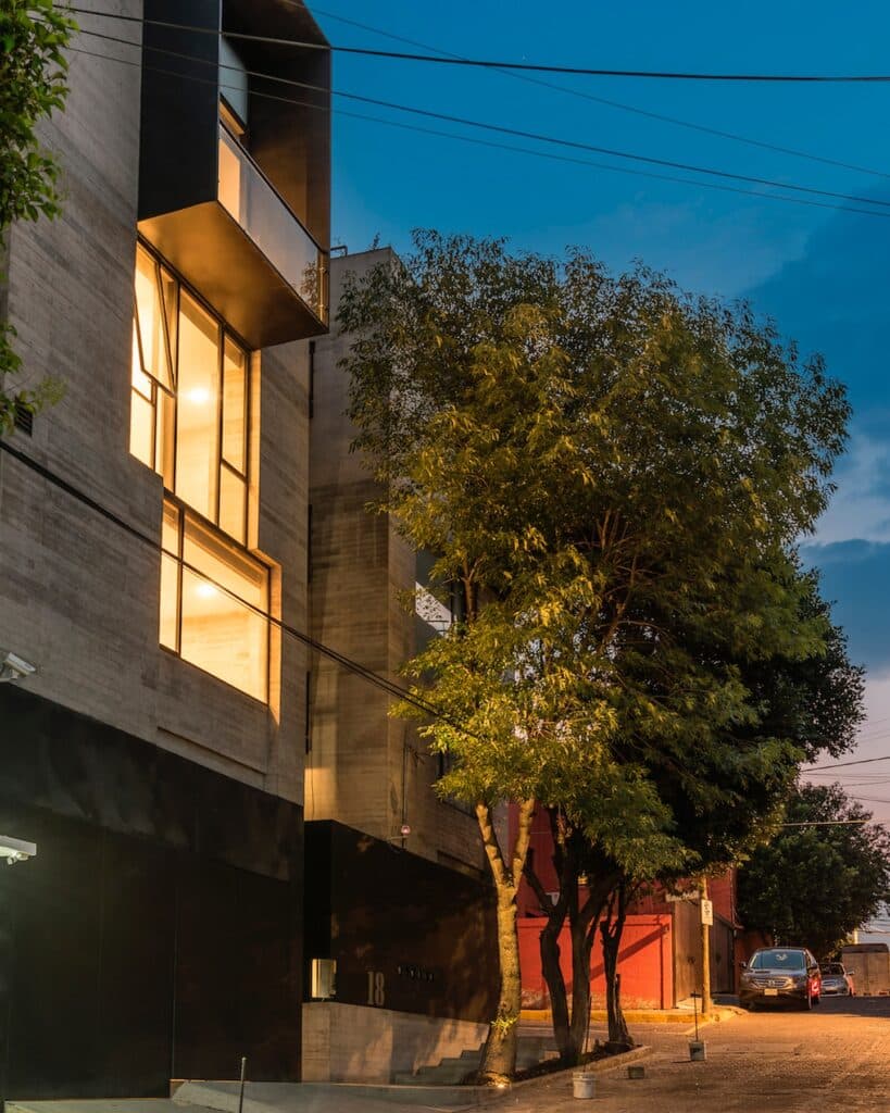 Exterior facade of Cuajimalpa residential project at evening with surrounding trees
