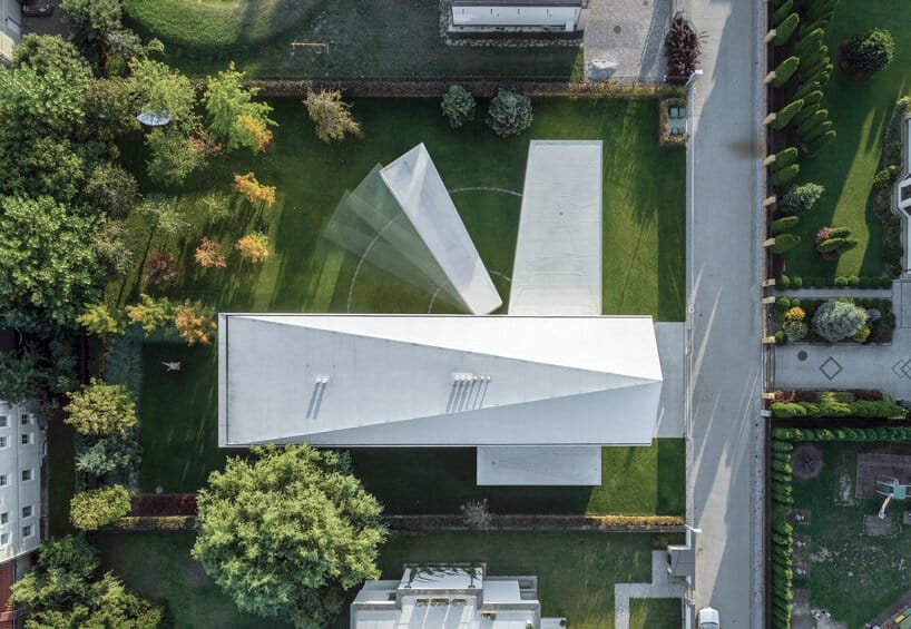 Aerial view of a modern house showing a rotating architectural element over a green lawn.