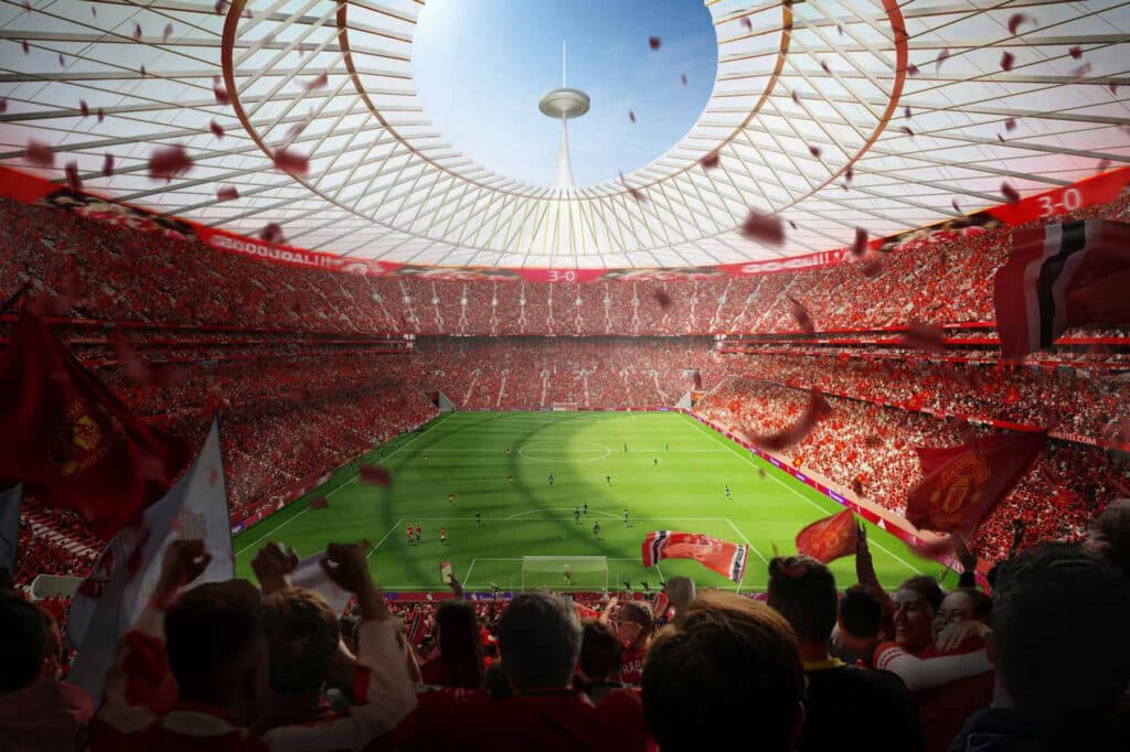 An interior view of the new Manchester United stadium filled with fans, showcasing the open canopy above the pitch.