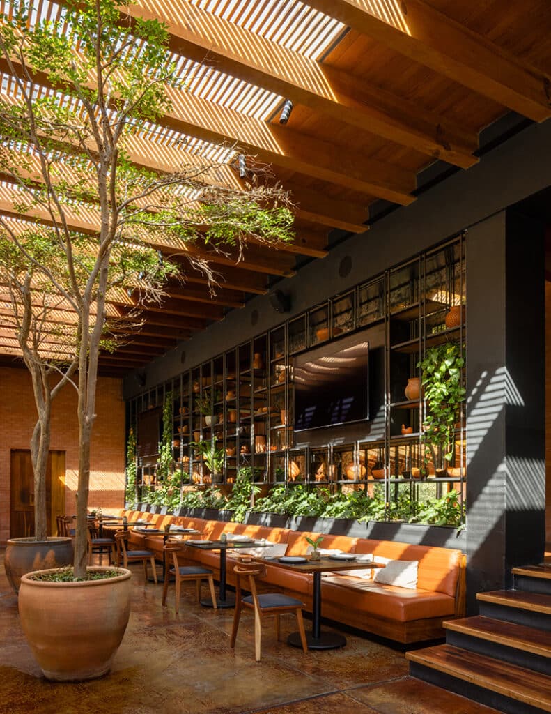 "Restaurant at Hotel Avándaro featuring a natural wood and greenery design with natural lighting from the ceiling."