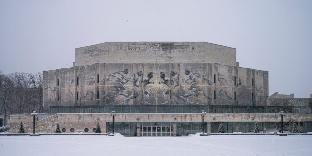 A monumental building in Ukraine featuring relief sculptures that symbolize Soviet-era modernist art, showcasing the beauty of Ukrainian architecture.