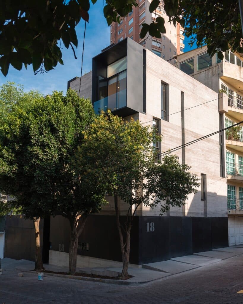 Exterior facade of Cuajimalpa residential project at evening with surrounding trees
