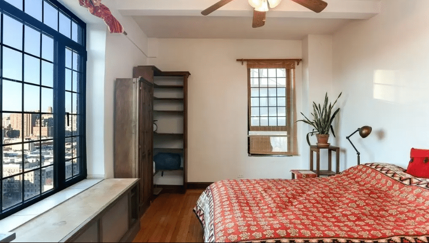 "A cozy bedroom with large windows and wooden furniture, demonstrating the importance of second engineering opinions in ensuring structural integrity and design quality."