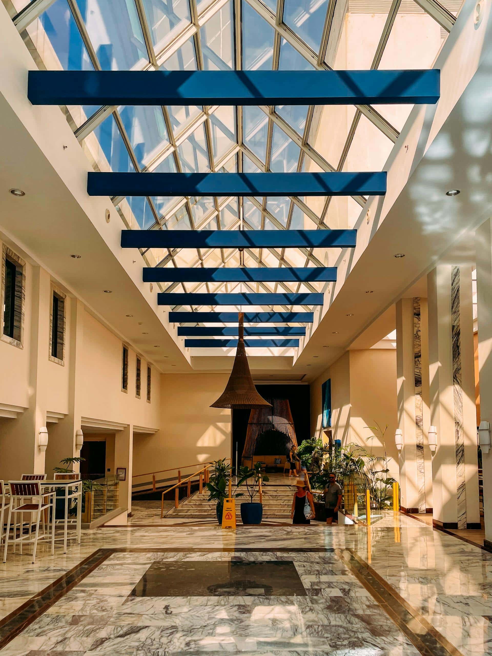 Elegant indoor atrium featuring glass ceiling and contemporary design elements.
