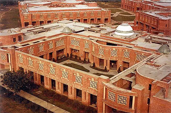 A large architectural complex featuring traditional design with red brick, ornate glass windows, flat roofs, and circular arches