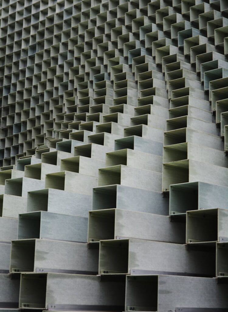 A photo of a building facade featuring an intricate geometric design with repetitive and precisely arranged shapes, showcasing creativity in modern architectural design.