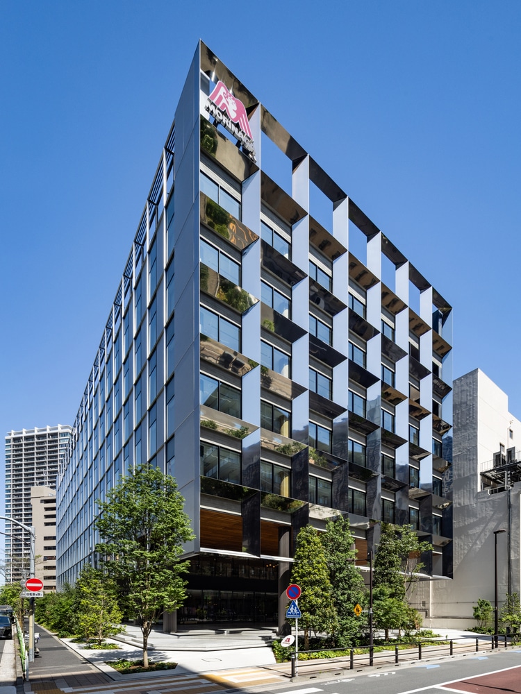 "واجهة مبنى Morinaga Shibaura تعكس دمجًا فريدًا بين التصميم الذكي والاستدامة، حيث تلتقي التكنولوجيا بالطبيعة في قلب طوكيو."