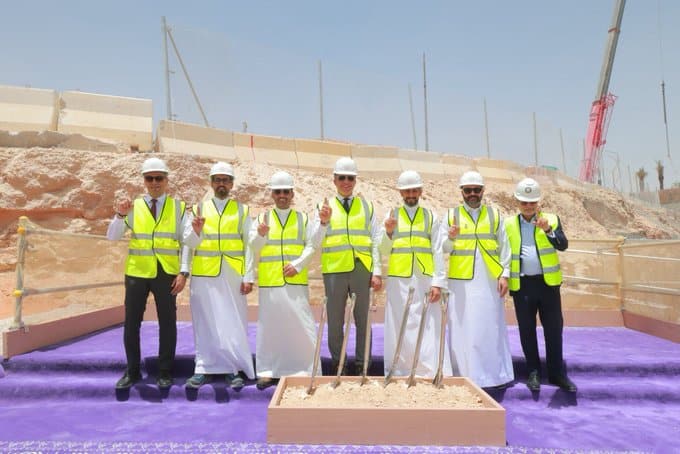 المسؤولين يشاركون في مراسم وضع حجر الأساس الرسمية لمتحف مسك للتراث، حيث يرتدون سترات أمان صفراء وقبعات بيضاء ويحملون أدوات بناء تقليدية