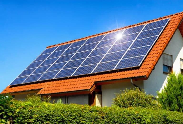 Solar panels installed on the roof of a house under bright sunlight, showcasing the efficiency of renewable energy in homes.