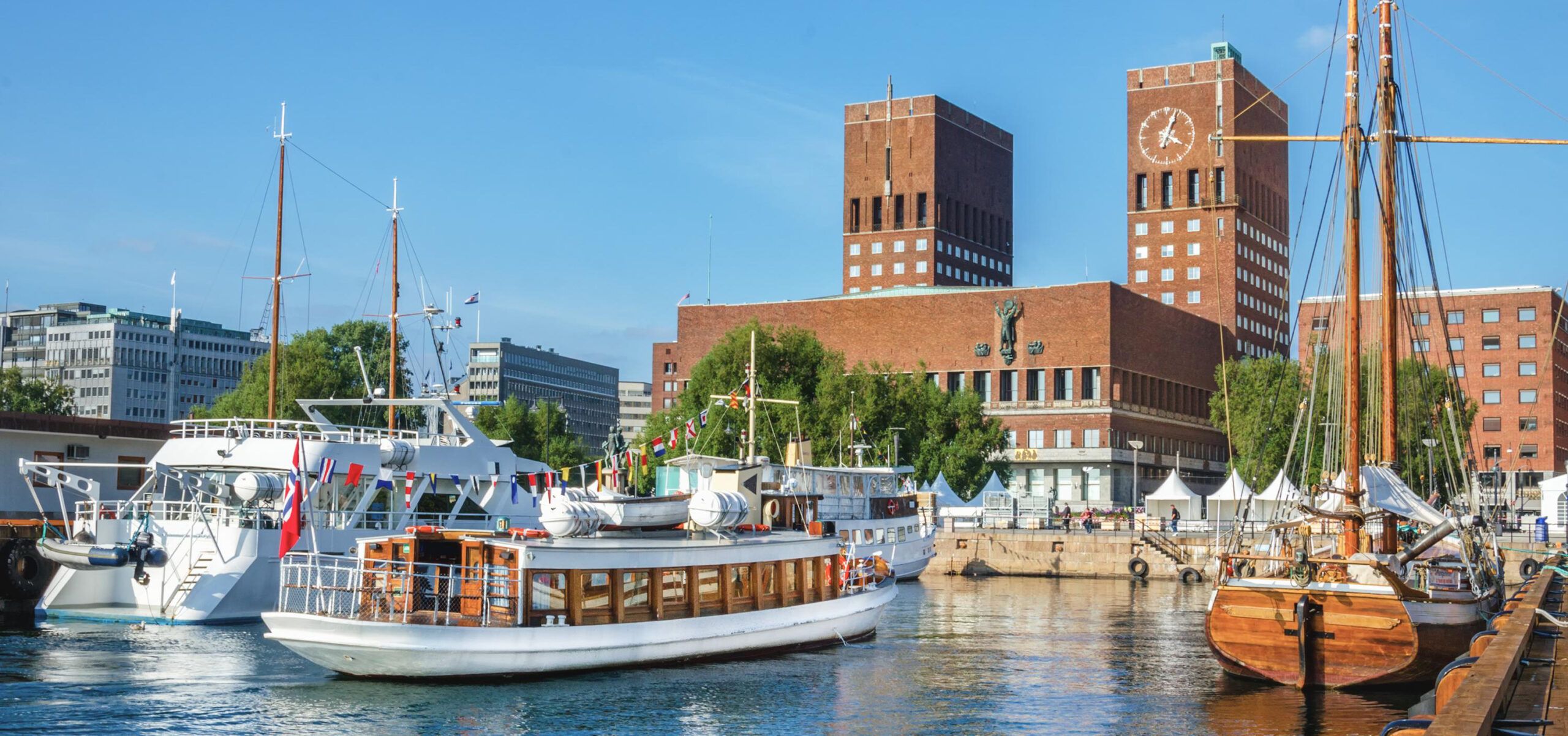 Oslo harbor showcasing the city's urban transformation with modern buildings and traditional boats."