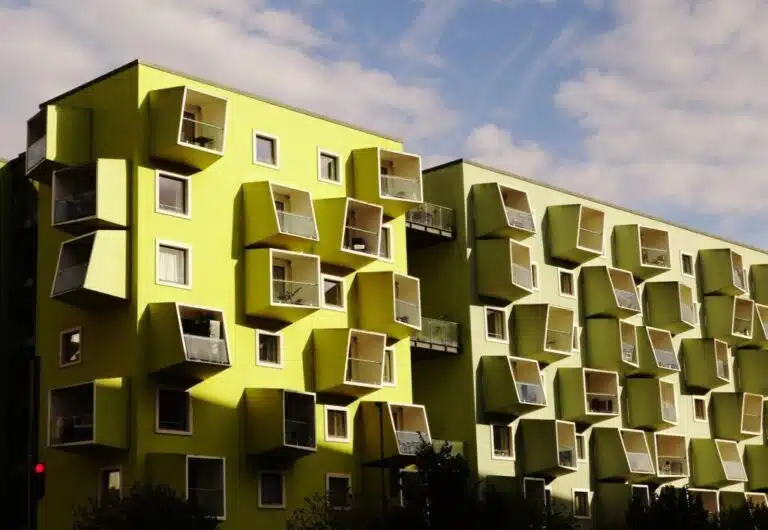 A modern building in Copenhagen with vibrant green and yellow facades, representing sustainable architecture."