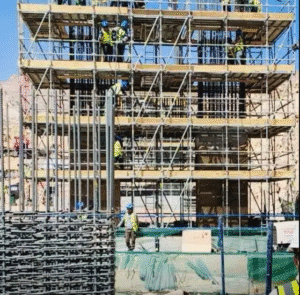 Construction workers on scaffolding during the early phase of building the Trojena Lake Bridge in NEOM