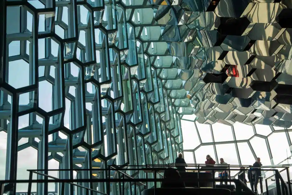 An innovative glass facade composed of interlocking geometric shapes, reflecting light and shadow in an artistic manner, creating a modern and distinctive atmosphere in the building.