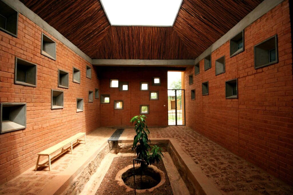 "Sustainable interior design by Francis Kéré, utilizing natural materials and natural ventilation."