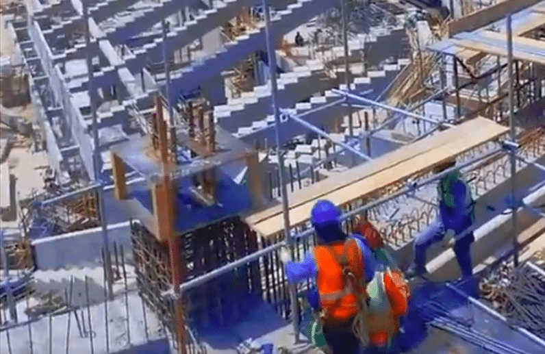 Construction workers are actively installing scaffolding and formwork systems on the upper tier of Aramco Stadium in Dammam. The site is bustling with activity, showcasing a well-coordinated effort to build the stadium's structure.
