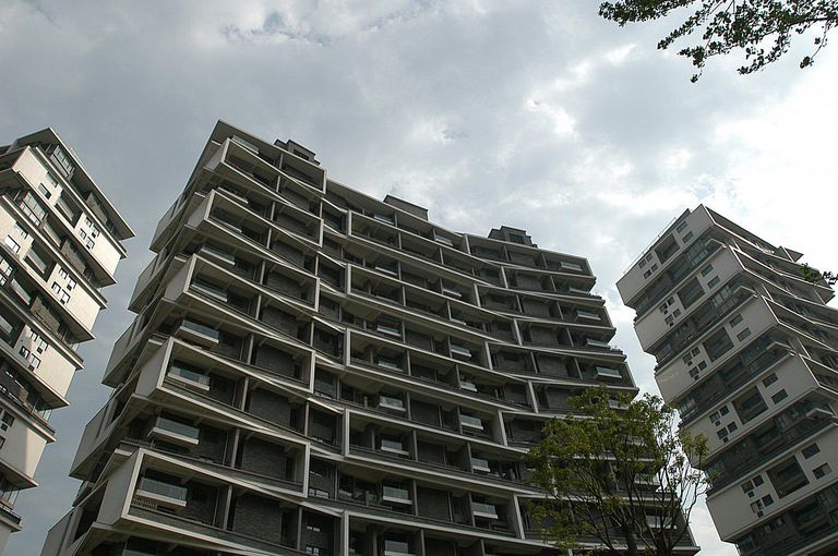 مجموعة من المباني السكنية الحديثة متعددة الطوابق، ذات تصميم هندسي نظيف وأنيق. تتميز المباني بشرفات خارجية ونوافذ كبيرة