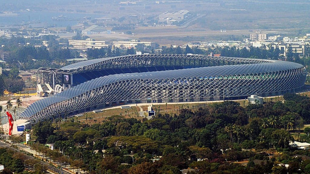 "A sleek, curved architectural design reflecting Toyo Ito's philosophy, featuring a building covered with a glass lattice that highlights the integration of nature and technology."