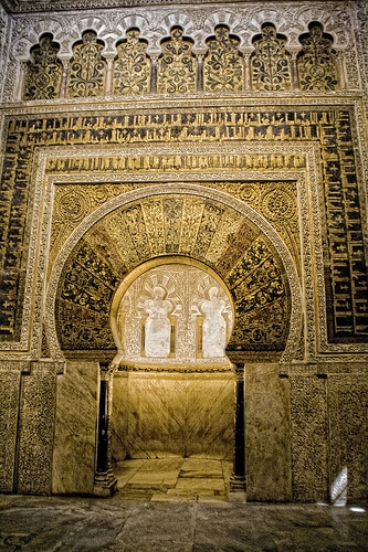 "The Cordoba Mosque’s mihrab adorned with golden mosaics and Quranic inscriptions."