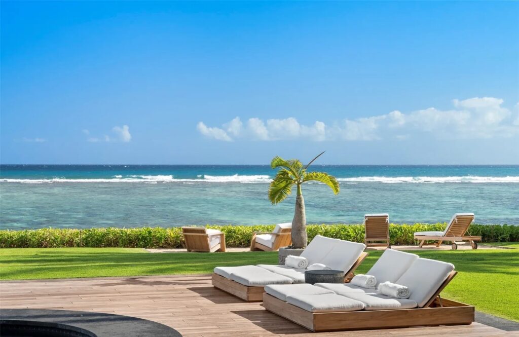 Oceanfront luxury home in Kahala with glass walls and tropical landscaping