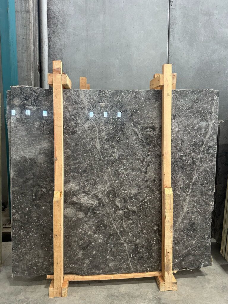 Gray marble slabs supported by a wooden frame during marble manufacturing in the factory