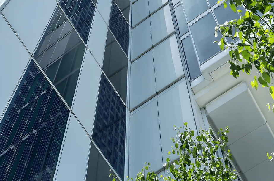 A modern building facade with integrated solar panels in the glass, showcasing how solar energy can be seamlessly and aesthetically incorporated into architectural design