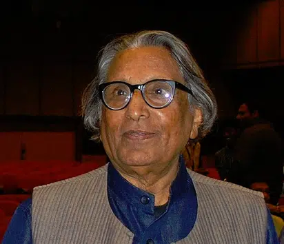 "A man wearing glasses, appearing at what seems to be a formal or celebratory event.
