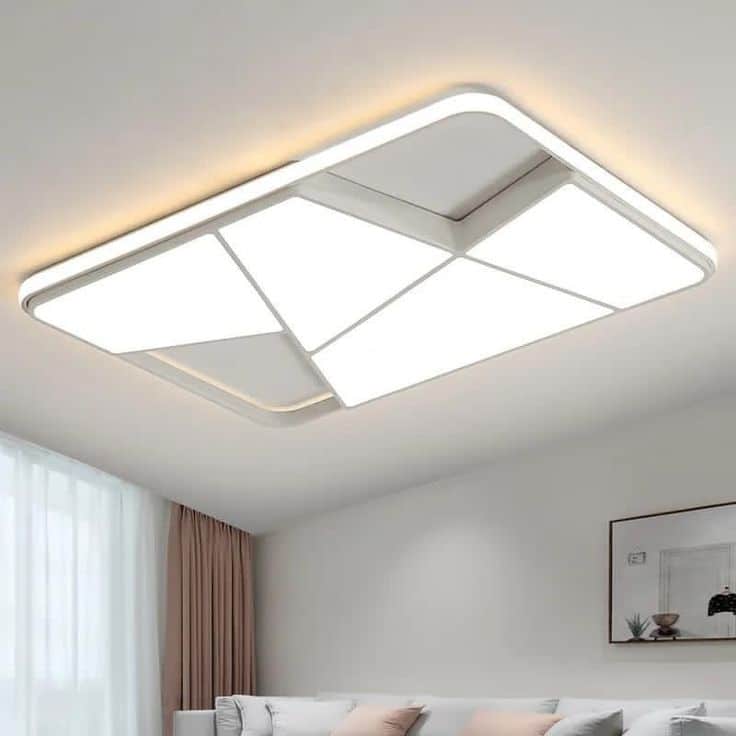 مصباح LED معلق على سقف غرفة نوم معاصرة، يُضيء الغرفة بشكل متساوٍ ودائم، مع إضاءة طبيعية تدخل من النافذة المغطاة بالستائر