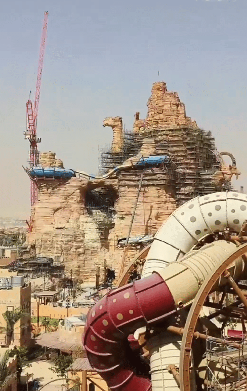 Construction progress at Aquaria Park in Qiddiya City, showcasing expansive water areas surrounded by palm trees
