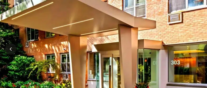 : "Co-op building entrance in Upper West Side with modern lighting and design."