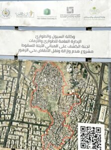 An aerial view of a densely populated urban area, with a highlighted red boundary outlining the Al-Zuhur neighborhood in Makkah. The image includes logos of various governmental and municipal entities involved in the urban redevelopment project. A QR code is visible in the bottom right corner, likely providing additional information about the clearance process.