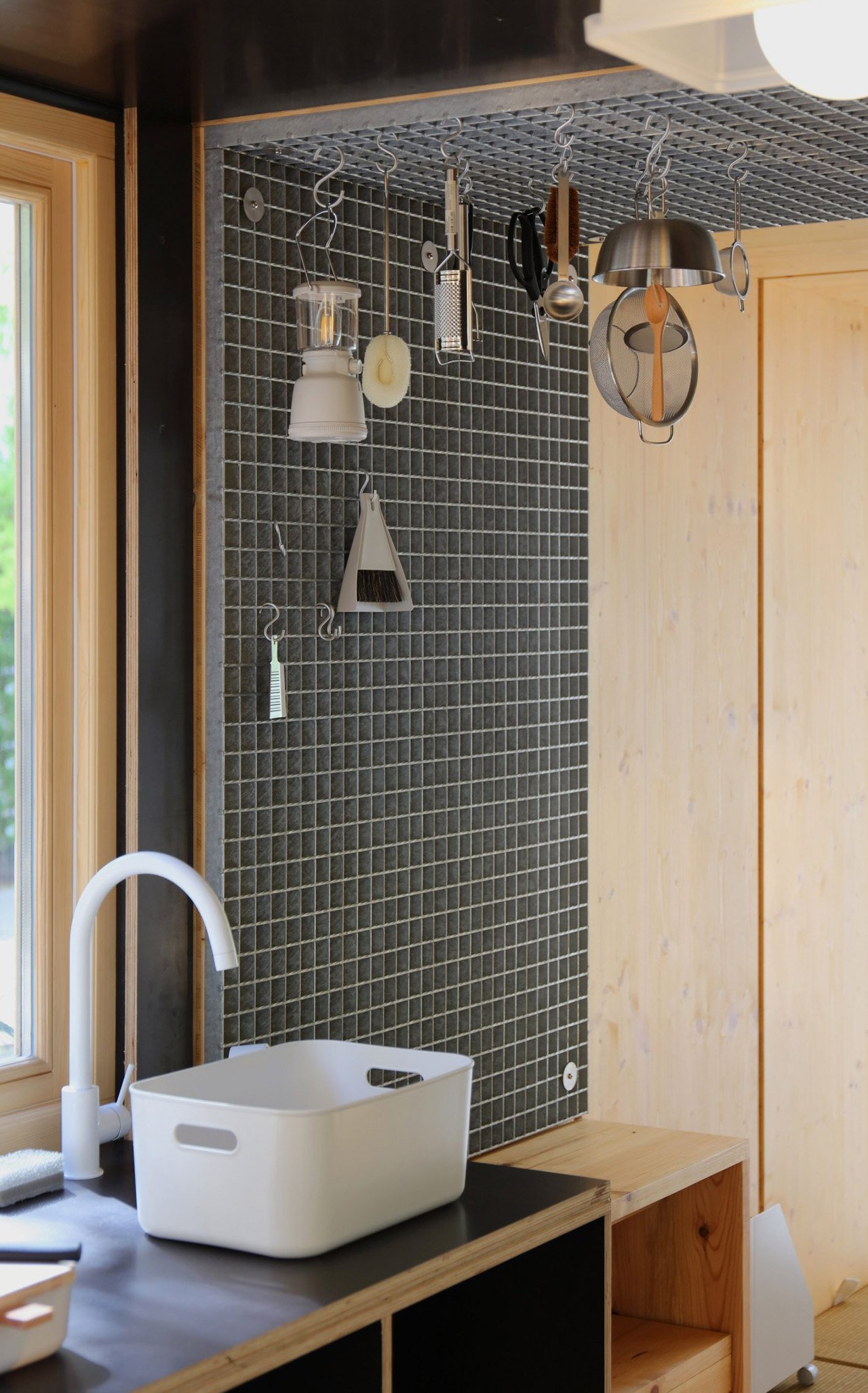 Modular kitchen with hanging metal grids and stackable jars for efficient storage