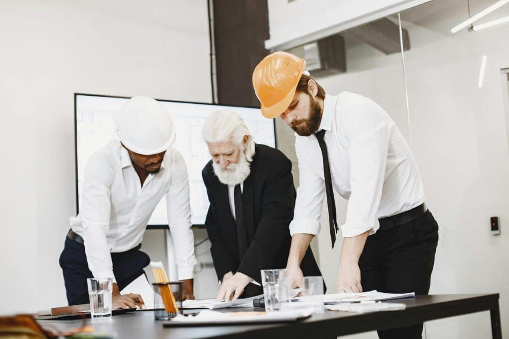 Engineers holding a project blueprint, collaborating to ensure accurate planning and execution.