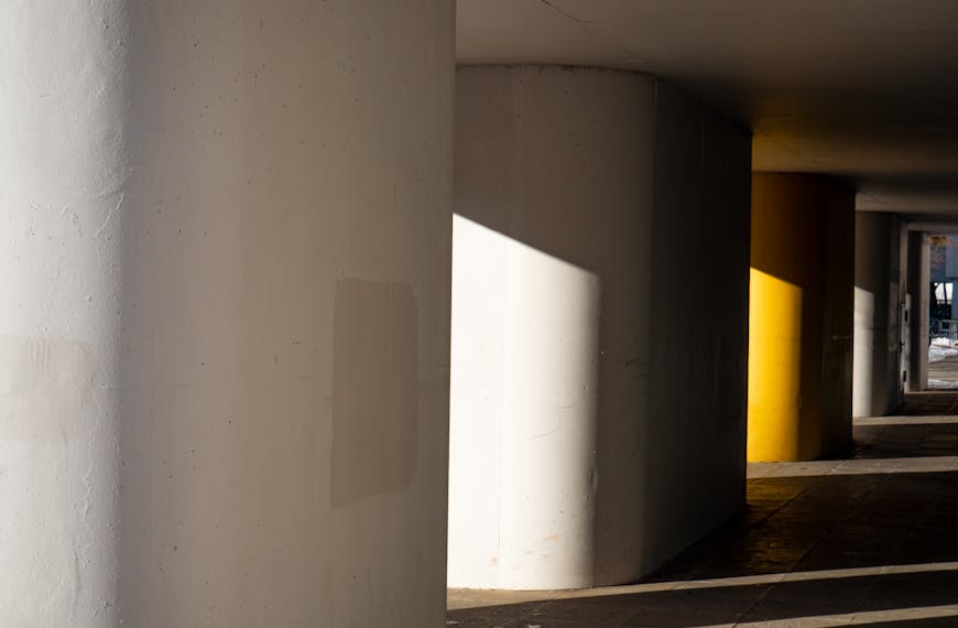 Sunlit concrete corridor showcasing architectural design and light interplay.