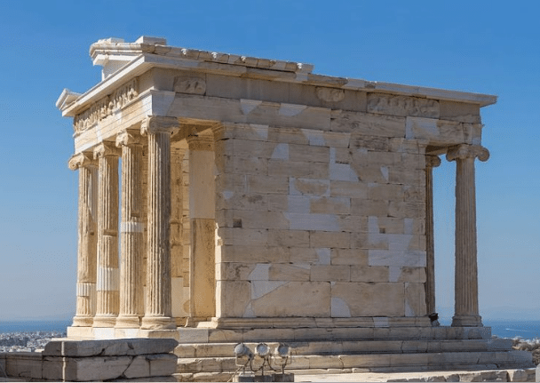 An ancient temple with massive Doric columns and ornate pediments under a clear sky.