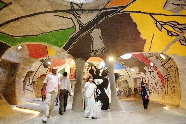 A group of people walking through a vibrant, colorful space with walls adorned with bright colors and geometric shapes.