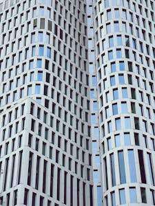A photo of a high-rise building facade showcasing a modern and sleek design with glass and metallic materials, reflecting contemporary architectural technology