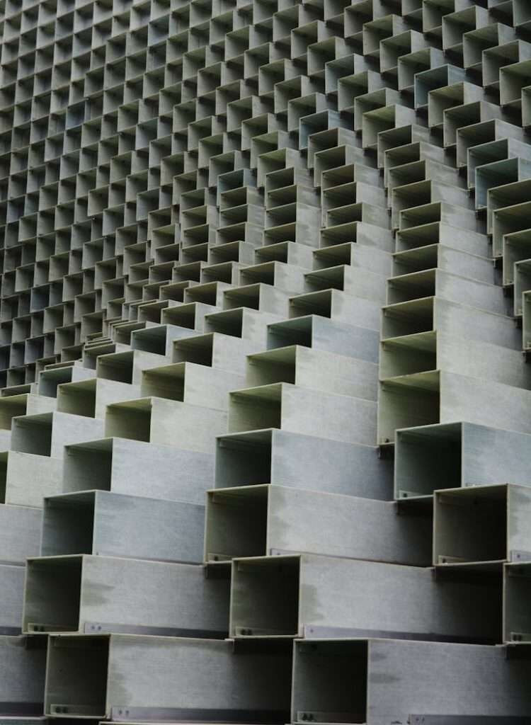 A photo of a building facade featuring an intricate geometric design with repetitive and precisely arranged shapes, showcasing creativity in modern architectural design.