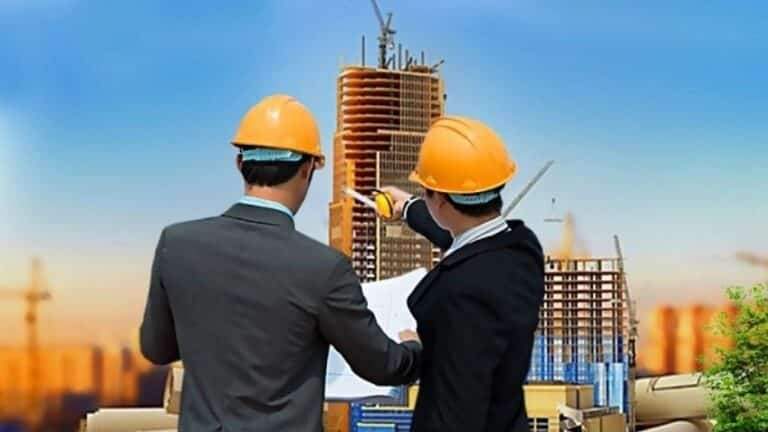 "Two engineers reviewing plans near a construction site"