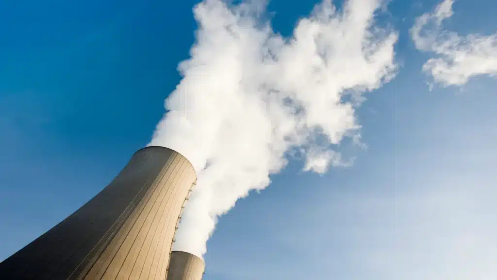 An industrial site emitting smoke stacks, possibly part of the nuclear waste storage infrastructure in Ontario’s deep geological repository project.