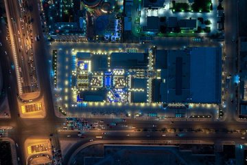 An aerial view of Oro Square in Riyadh at night, showcasing its innovative design and colorful lighting.