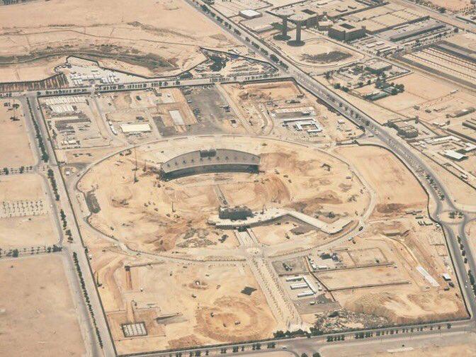 Aerial view of King Fahd Stadium in Riyadh, showing the dismantling of temporary structures and grandstands following the 2034 FIFA World Cup. The exposed sandy ground indicates ongoing renovation efforts as part of a broader plan to repurpose the stadium for future community use.