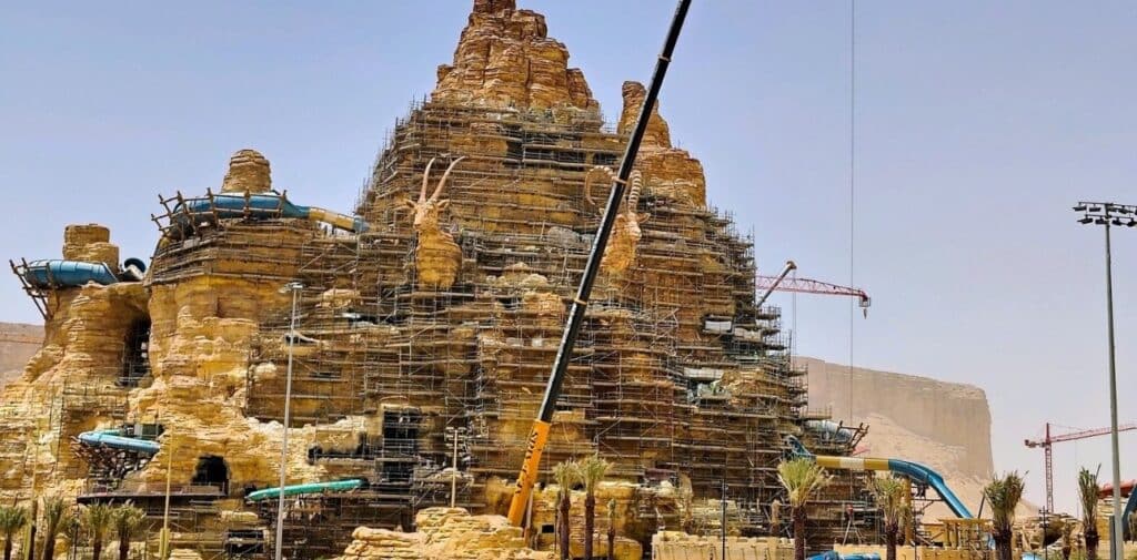 Construction of a massive mountain-shaped structure in Qiddiya entertainment city, featuring integrated water slides and sculpted rock details