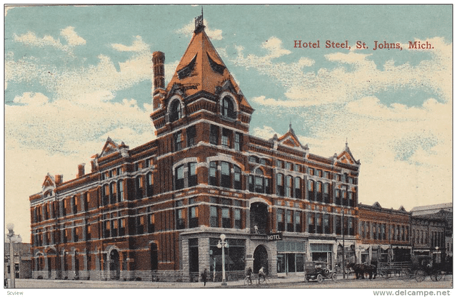 The Steel Hotel in Saint Johns, Michigan, showcasing its late Gothic Revival style with a striking red brick facade and arched windows, reflecting the beauty of 19th-century architecture.